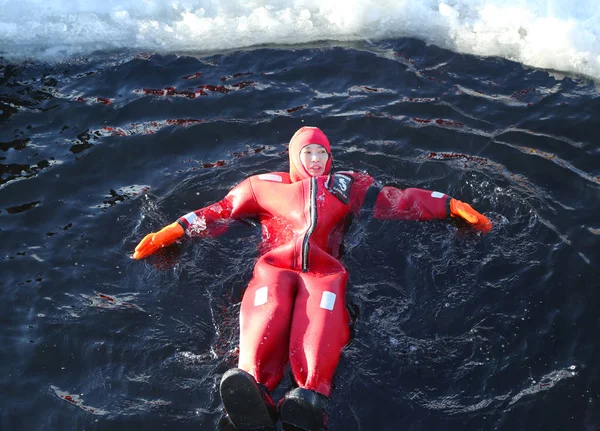 正体不明の観光客が冷凍バルト海でサバイバル スーツ氷泳ぎ連動. — ストック写真