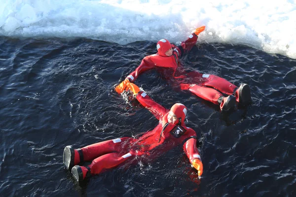 Unbekannte mit Überlebensanzug beim Eisschwimmen in zugefrorener Ostsee. — Stockfoto