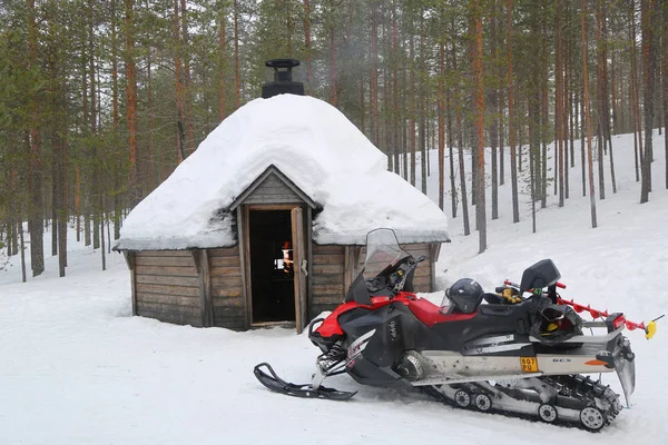 Neve móvel na frente da Kota finlandesa em uma paisagem coberta de neve . — Fotografia de Stock