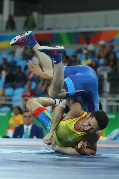 Luchadores Ibragim Labazanov de Rusia (en azul) y Almat Kebispayev de Kazajstán durante Hombres Greco-Romano 59 kg Calificación de los Juegos Olímpicos de Río 2016 — Foto de Stock