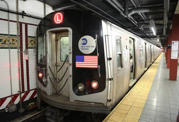 Поезд метро Нью-Йорка L прибывает на станцию Восьмой авеню в Манхэттене — стоковое фото