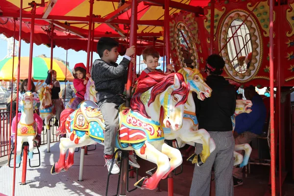 Kinder und Erwachsene fahren auf dem Coney Island Karussell im Luna Park an der Coney Island Promenade in Brooklyn — Stockfoto