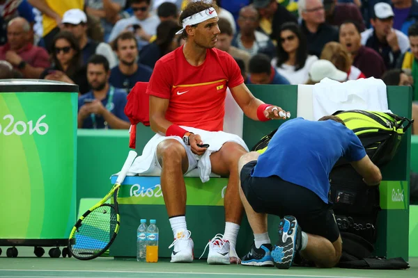 El campeón olímpico Rafael Nadal de España recibe asistencia médica durante los cuartos de final individuales de los Juegos Olímpicos de Río 2016 en el Centro Olímpico de Tenis — Foto de Stock