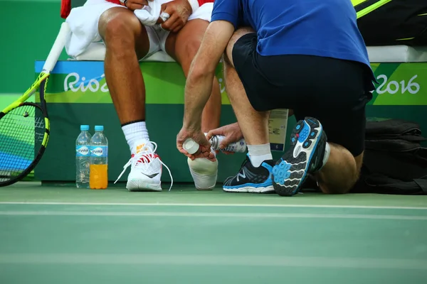 El campeón olímpico Rafael Nadal de España recibe asistencia médica durante los cuartos de final individuales de los Juegos Olímpicos de Río 2016 en el Centro Olímpico de Tenis —  Fotos de Stock