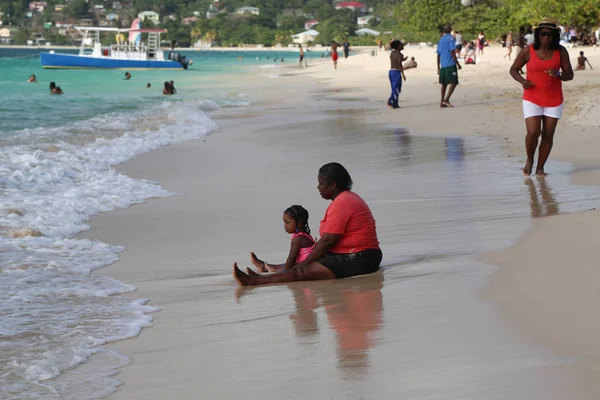 Local residents enjoy sunny day at Grand Anse Beach in Grenada. — Stock Photo, Image