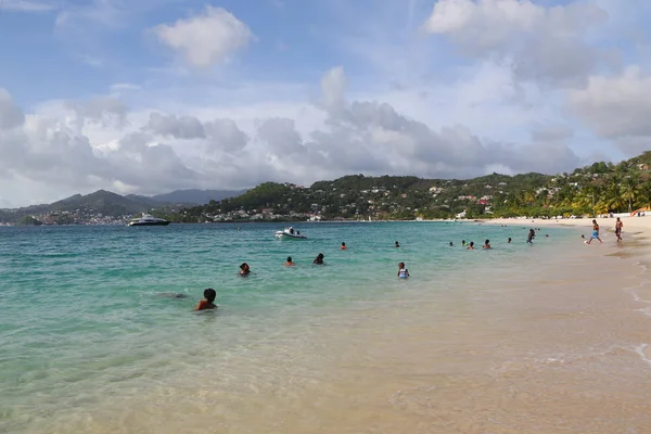 Местные жители наслаждаются солнечным днем на пляже Гранд Анс в Гренаде . — стоковое фото