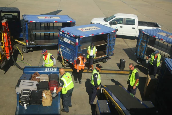 Operadores de bagagem da American Airlines que carregam bagagem no Aeroporto Internacional de Miami — Fotografia de Stock