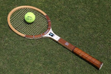 Vintage Wilson Cris Evert tennis racket and Slazenger Wimbledon Tennis Ball on the grass tennis court.  clipart