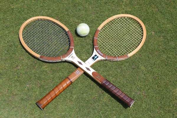 Vintage tennisrackets en antiek wit tennisbal op de tennisbaan gras. — Stockfoto