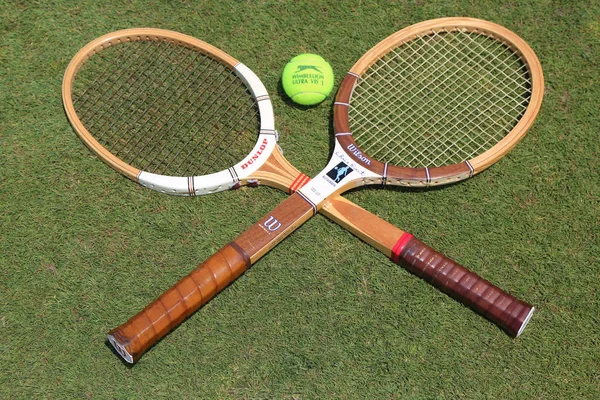 Raquetas de tenis vintage y Slazenger Wimbledon Tennis Ball en cancha de tenis de hierba — Foto de Stock