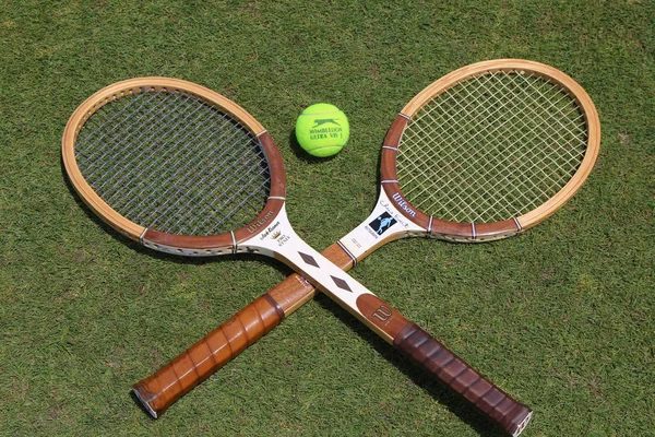 Raquetes de tênis vintage e bola de tênis Slazenger Wimbledon na quadra de tênis de grama — Fotografia de Stock