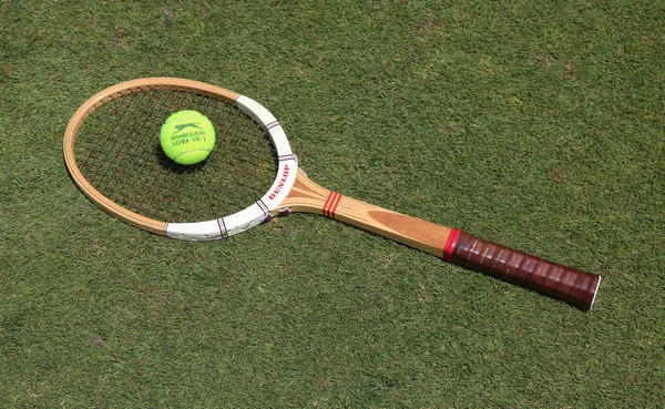 Raquette de tennis vintage Dunlop et balle de tennis Slazenger Wimbledon sur le court de tennis en herbe . — Photo