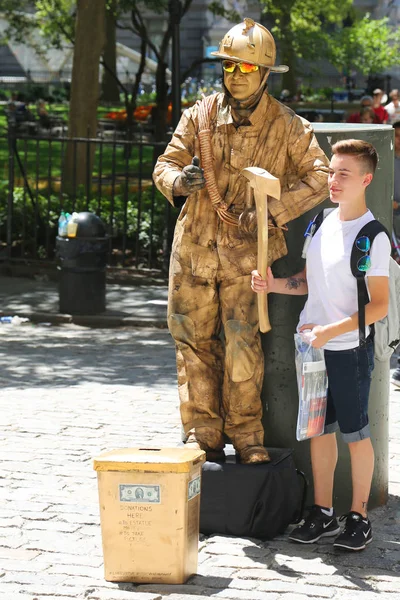 Tourist takes picture with firefighter human statue in Lower Manhattan. — Stock Photo, Image