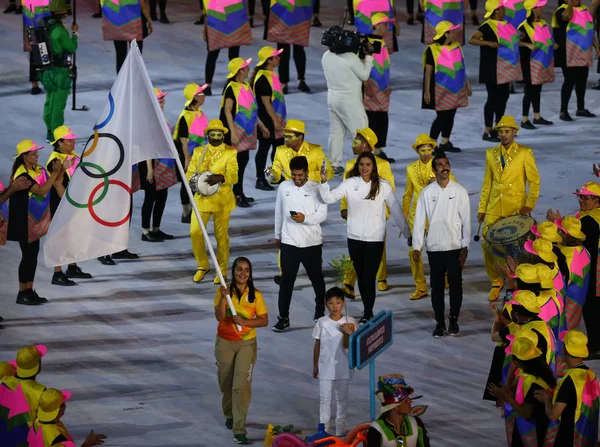 El equipo olímpico de refugiados camina hacia Río 2016 Ceremonia de apertura de los Juegos Olímpicos mientras marchan bajo la bandera olímpica en el estadio de Maracana —  Fotos de Stock