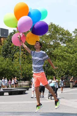 Kimliği belirsiz adam at Washington Square New York'ta hava balonları ile poz