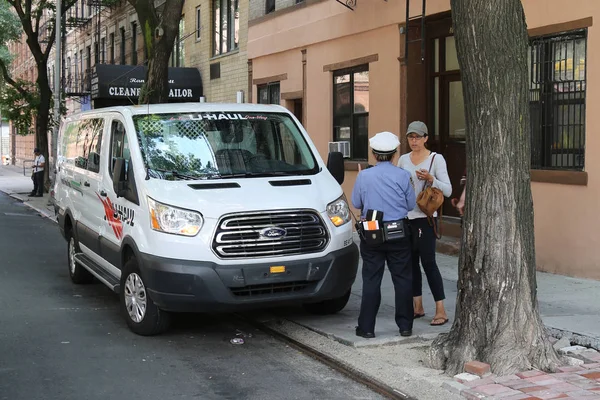 Сотрудник дорожного контроля Нью-Йорка спорит с водителем о нарушении правил парковки в Нижнем Манхэттене — стоковое фото