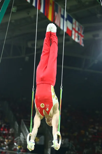 Bronze medalist gymnast Denis Abliazin of Russian Federation competes at the Men's Rings Final on artistic gymnastics competition at Rio 2016 Olympic Games — Stock Photo, Image