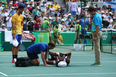 Professional tennis player Dustin Brown of Germany needs medical attention during first round match of the Rio 2016 Olympic Games clipart