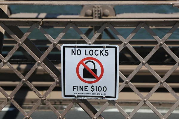 Schild auf der Brooklyn Bridge warnt vor einem Bußgeld von $100, wenn Sie ein Schloss auf der Brücke anbringen — Stockfoto