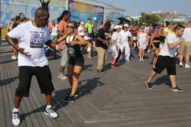  People dance on the Coney Island Boardwalk in Brooklyn clipart