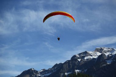 Interlaken, İsviçre - 5 Mayıs 2017: Tandem yamaç paraşütü uçuşları İsviçre Alpleri'nde Interlaken, İsviçre üzerinden 