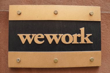NEW YORK - DECEMBER 12, 2017: WeWork office in Manhattan. WeWork is an American company which provides shared workspaces, technology startup subculture communities, and services for entrepreneurs clipart