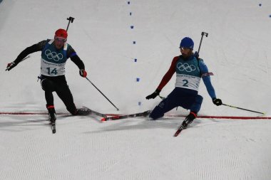 Pyeongchang, Güney Kore 18 Şubat 2018: Olimpiyat Şampiyonu Martin Fourcade France (R), Almanya için Simon 2018 Kış Olimpiyatları'nda biatlon erkekler 15 km toplu çıkış kazanmak için Schempp kenarlı.