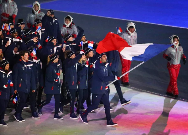 ピョンチャン 2018 オリンピック チャンピオン Martin Fourcade 2018年冬季オリンピックの開会式の間にフランスのオリンピックのチームを率いてフランス国旗を運ぶ — ストック写真