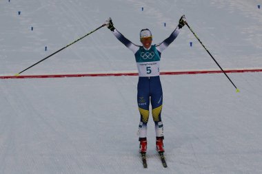Pyeongchang, Güney Kore - 10 Şubat 2018: Olimpiyat Şampiyonu Charlotte Kalla İsveç'in bitiş çizgisine bayanlar 7.5 km + 7.5 km Skiathlon 2018 Kış Olimpiyatları'nda toplu çıkış sırasında