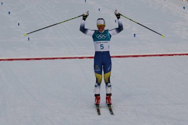 Pyeongchang, Güney Kore - 10 Şubat 2018: Olimpiyat Şampiyonu Charlotte Kalla İsveç'in bitiş çizgisine bayanlar 7.5 km + 7.5 km Skiathlon 2018 Kış Olimpiyatları'nda toplu çıkış sırasında