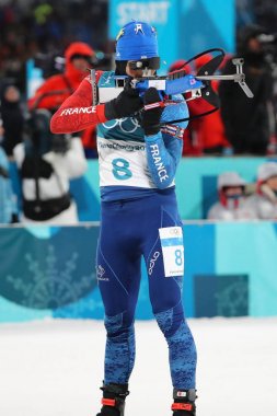 PYEONGCHANG, SOUTH KOREA - FEBRUARY 12, 2018: Olympic champion Martin Fourcade of France competes  in biathlon men's 12.5km pursuit at the 2018 Winter Olympics in Alpensia Biathlon Centre clipart