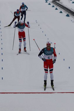 Pyeongchang, Güney Kore - 11 Şubat 2018: gümüş madalya Martin Johnsrud Sundby Norveç'in bitiş çizgisinde erkekler 15 km + 15 km Skiathlon 2018 Kış Olimpiyat Oyunları'nda toplu çıkış