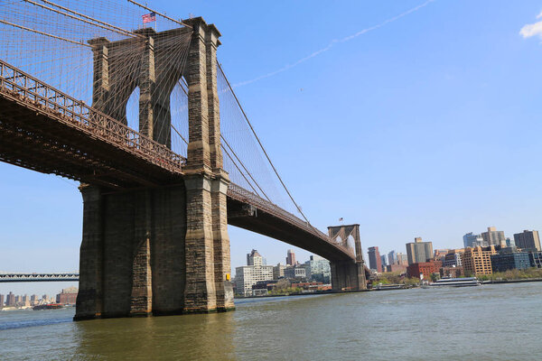 NEW YORK - MAY 3, 2018: Famous Brooklyn Bridge view from South Street Seaport. The Brooklyn Bridge is the one of the oldest suspension bridges in the USA was completed in 1883