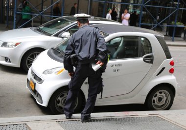 NEW YORK - MAY 10, 2018: NYPD traffic control officer writing parking violation in Lower Manhattan clipart