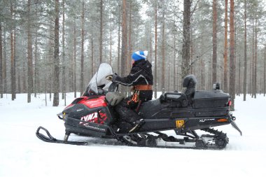 Rovaniemi, Finlandiya - 19 Şubat 2017: Finlandiya 'nın Laponya bölgesindeki Rovaniemi' de kimliği belirsiz bir kadın kar aracına biniyor. 