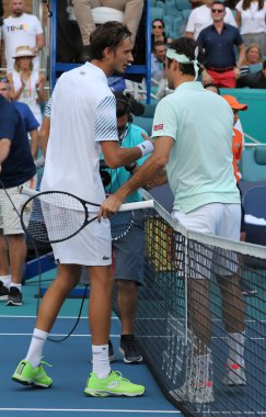 Miami Gardens, Florida - 27 Mart 2019: İsviçre (R) Grand Slam şampiyonu Roger Medvedev, 2019 Miami Açık 'ta oynanan 16 rauntluk maçın ardından Daniil Medvedev' i ağda kucakladı. 