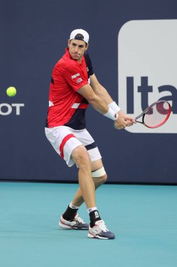 Miami Gardens, Florida-27 Mart, 2019: ABD 'nin profesyonel tenis oyuncusu John Isner, Miami Gardens, Florida 'daki Hard Rock Stadı 'nda 2019 Miami Open 'ta çeyrek final maçında eylem yapıyor