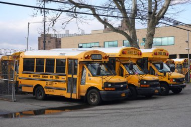 BROOKLYN, NEW YORK - MARCH 17, 2020: School buses parked on the yard in Brooklyn, NY after New York City closed down the public school system to stop the spread of the coronavirus (COVID-19)