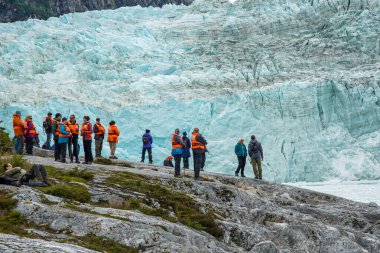 TIERRA DEL FUEGO, ŞİLİ - 2 Şubat 2020: Ventus Australis keşif gemisinden turistler Patagonya, Şili 'deki Parque Nacional Alberto de Agostini' de Pia buzulunun kıyısına indi.