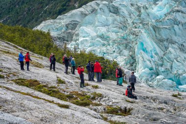 TIERRA DEL FUEGO, ŞİLİ - 2 Şubat 2020: Ventus Australis keşif gemisinden turistler Patagonya, Şili 'deki Parque Nacional Alberto de Agostini' de Pia buzulunun kıyısına indi.