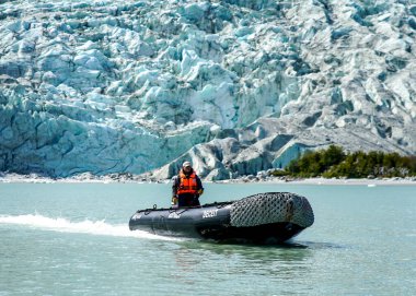 TIERRA DEL FUEGO, ŞİLYE - 2 Şubat 2020: Ventus Australis keşif gemisinden Zodiac botları Patagonya 'daki Parque Nacional Alberto de Agostini' de Pia buzulu yakınlarında turistleri kıyıya naklediyor