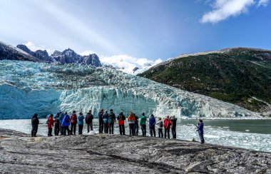 TIERRA DEL FUEGO, ŞİLİ - 2 Şubat 2020: Ventus Australis keşif gemisinden turistler Patagonya, Şili 'deki Parque Nacional Alberto de Agostini' de Pia buzulunun kıyısına indi.