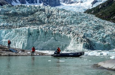 TIERRA DEL FUEGO, ŞİLYE - 2 Şubat 2020: Ventus Australis keşif gemisinden Zodiac botları Patagonya 'daki Parque Nacional Alberto de Agostini' de Pia buzulu yakınlarında turistleri kıyıya naklediyor