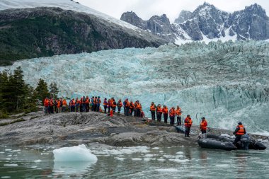TIERRA DEL FUEGO, ŞİLİ - 2 Şubat 2020: Ventus Australis keşif gemisinden turistler Patagonya, Şili 'deki Parque Nacional Alberto de Agostini' de Pia buzulunun kıyısına indi.