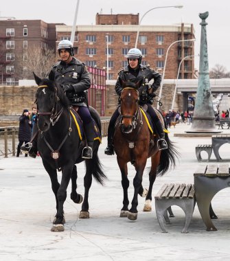 BROOKLYN, NEW YORK - MARCH 30, 2020: New York Police Department mounted unit police officers protect public during USNS Comfort Hospital Ship arrival in Brooklyn, New York clipart