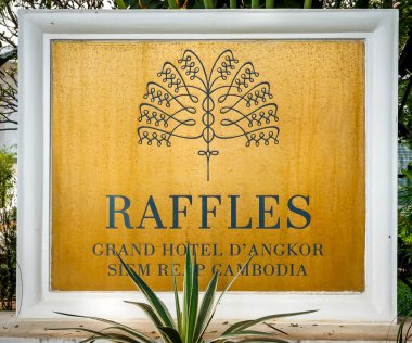 SIEM REAP, CAMBODIA - NOVEMBER 7, 2019: Sign at the historic luxury Raffles Grand Hotel d'Angkor in heart of Siem Reap, Cambodia. First opened in 1932, widely celebrated as La Grande Dame de Angkor clipart