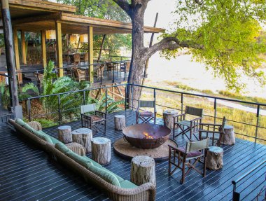 HAZYVIEW, SOUTH AFRICA - 1 Ekim 2018: Singita Ebony Lodge 'daki Kum Nehri' ne bakan ahşap havuz güvertesi
