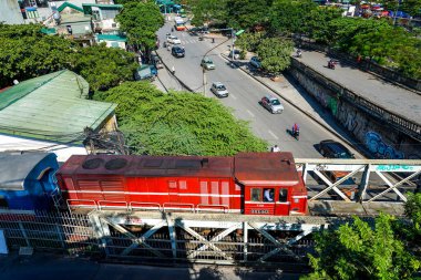 HANOI, VİETNAM - 28 Ekim 2019: Hanoi 'deki Hong (Kızıl) nehri üzerindeki ünlü Long Bien Köprüsü' nden geçen kırmızı lokomotif. Köprü Fransız mimar Gustave Eiffel tarafından tasarlandı.