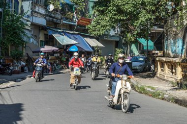 HANOI, VİETNAM - 28 Ekim 2019: Motosikletli insanlar Hanoi 'deki Hong (Kızıl) nehri üzerindeki Long Bien Köprüsü' nden çıkıyorlar. Köprü Fransız mimar Gustave Eiffel tarafından tasarlandı.