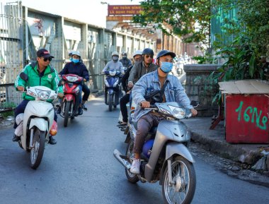 HANOI, VIETNAM - 28 Ekim 2019: Hanoi 'de Hong (Kızıl) nehri üzerinden Long Bien Köprüsü' nden geçen motosikletli insanlar. Köprü Fransız mimar Gustave Eiffel tarafından tasarlandı.